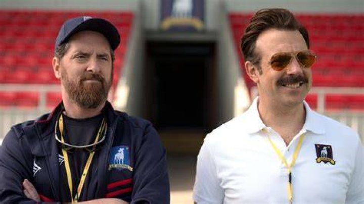 Coach Beard and Ted Lasso are standing together at a game.