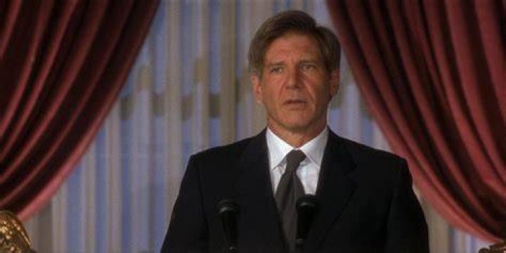 Harrison Ford is standing in front of a horse.