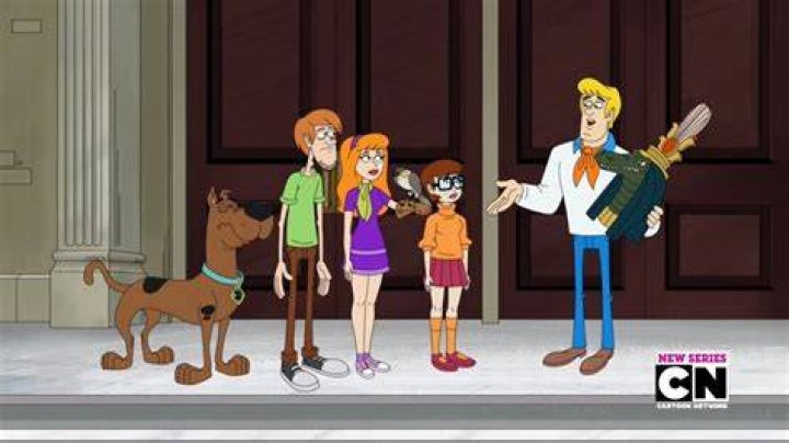 Scooby Doo looks guilty and is standing in a blue room. 